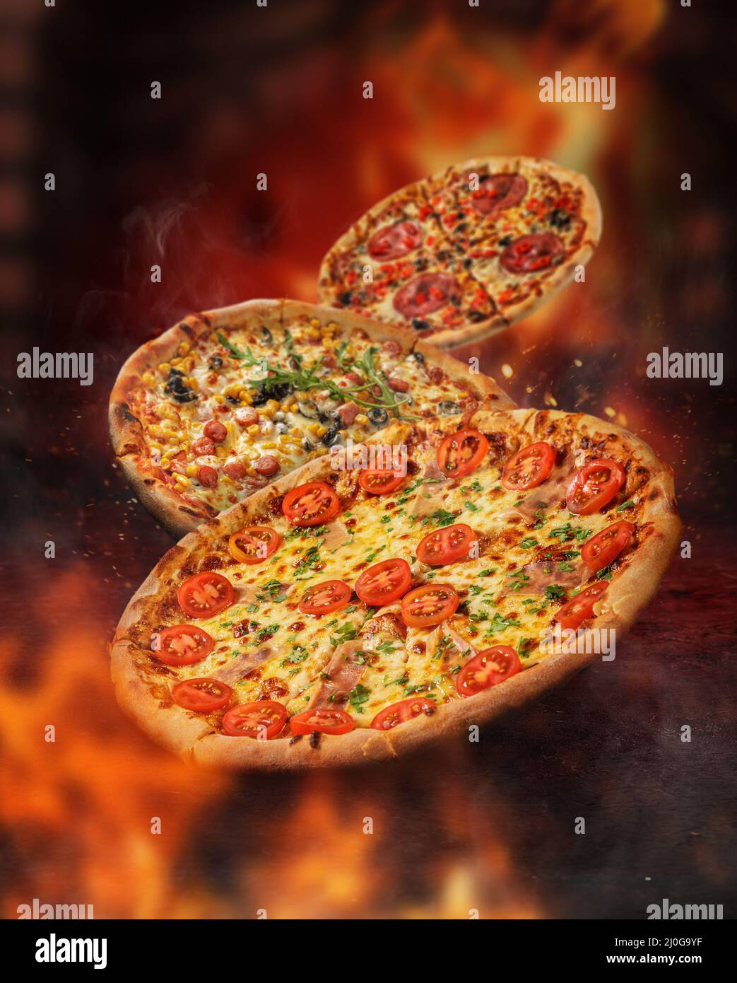 Pizza levitated in front of a burning oven. surrounded by flames Stock Photo