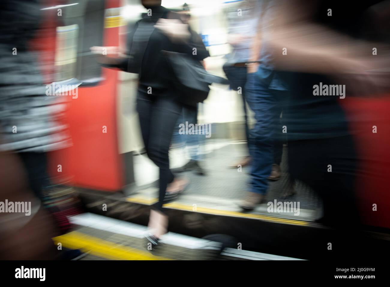Random passengers people at the underground tube station with moving train motion blurre. london, england UK Stock Photo