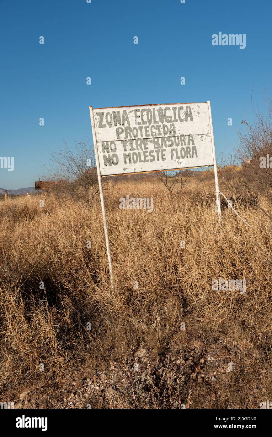 Sign in Spanish translated into English reads Protected Ecological Zone, Don't Throw Trash, and Do Not Disturb Plants, San Carlos, Sonora, Mexico. Stock Photo
