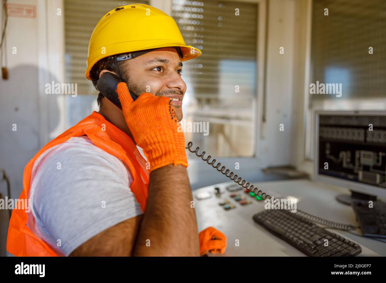 Smiling young construction specialist working in plant Stock Photo