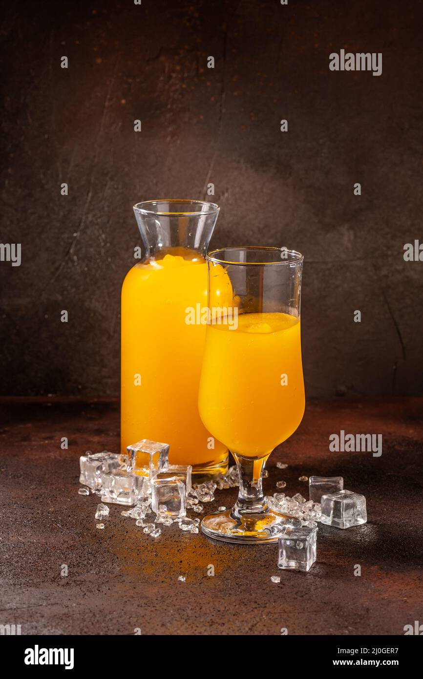 Delicious cold refreshing orange smoothie drink in cocktail glass Stock Photo