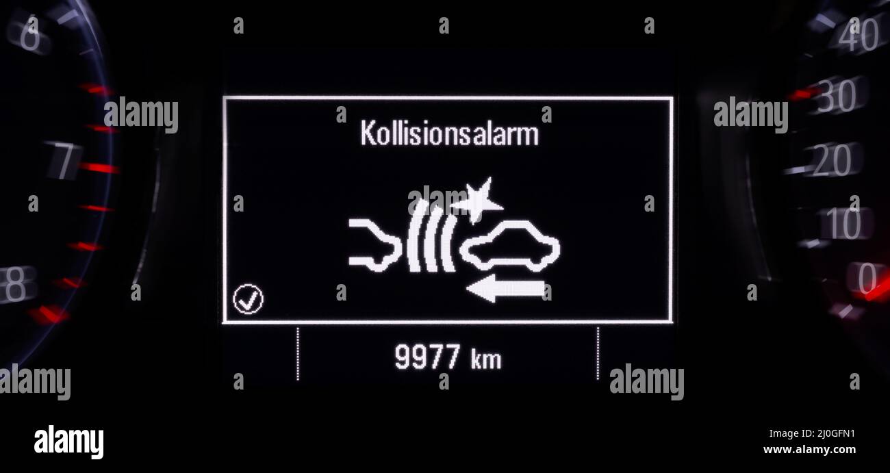 Collision warning (in German Kollisionsalarm) in the information display of a modern car Stock Photo