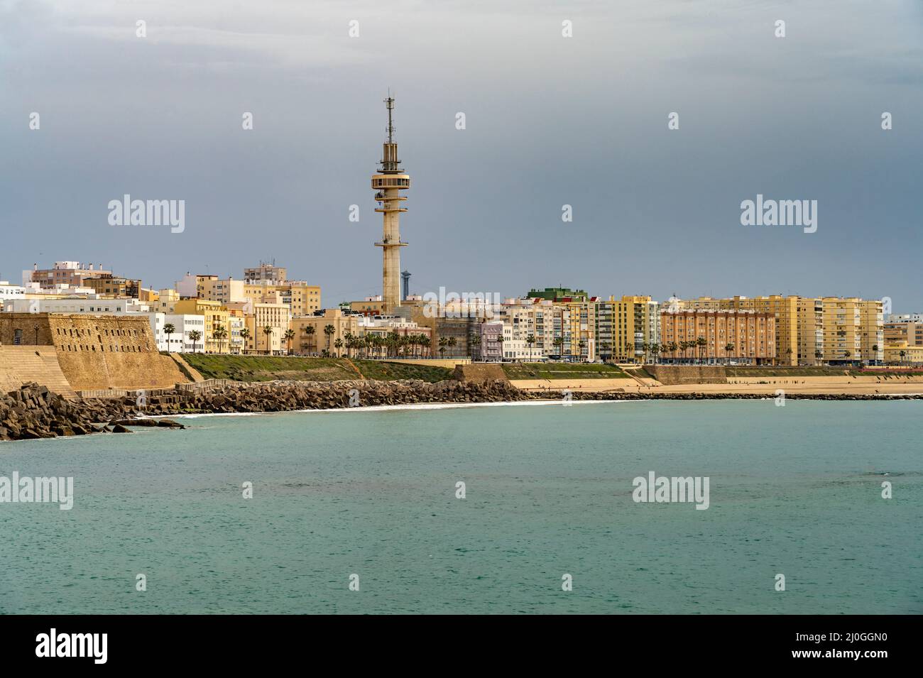 Die Küste mit dem Telekommunikations Turm La Torre Tavira II und dem Strand Playa de Santa María del Mar in Cádiz, Andalusien, Spanien  |  The coast w Stock Photo