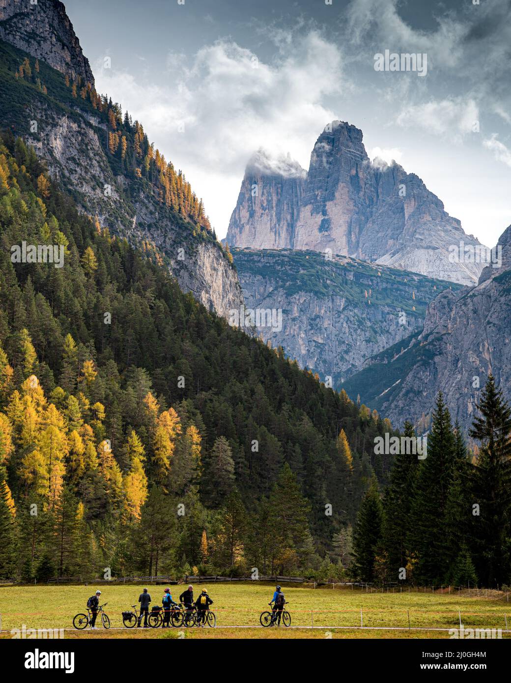Bikers bicycling on a trail at the dolomites in the Italian Alps in Italy Stock Photo