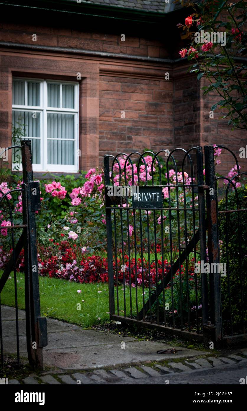 Front private entrance with metal railings to the flower garden of a British house. English countryside Stock Photo