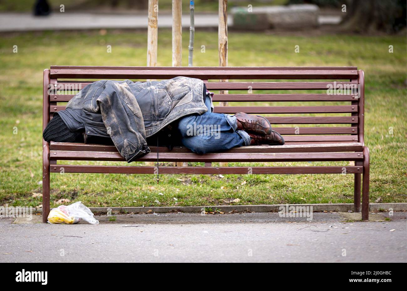 Homeless man sleeping on a bench Stock Photo Alamy
