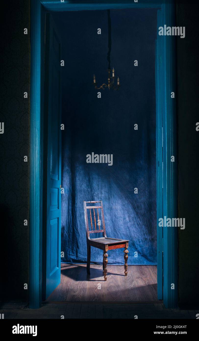 empty chair in light behind blue massive vintage doors indoor. Old