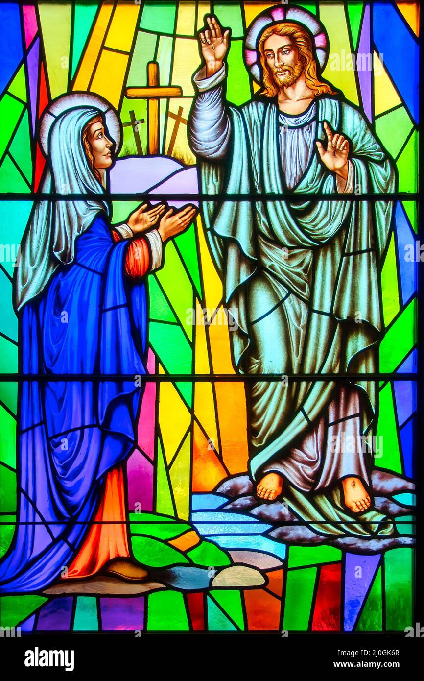 Jesus Christ and Virgin Mary. Stained-glass window with Christian religious symbols seen in the Annunciation of the Blessed Virgin Mary Catholic Chur Stock Photo