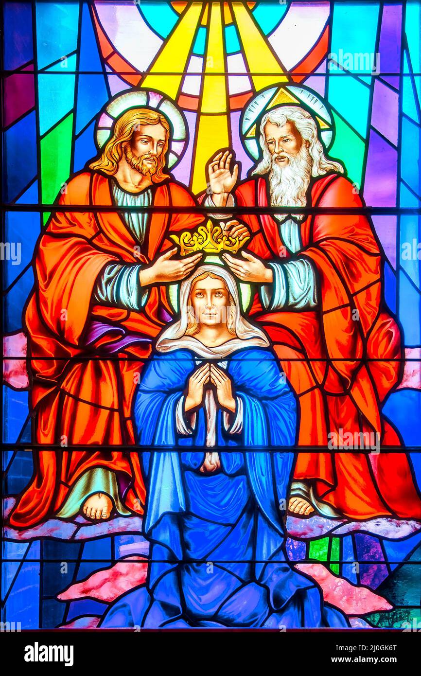Coronation of the Virgin. Stained-glass window with Christian religious symbols seen in the Annunciation of the Blessed Virgin Mary Catholic Church Stock Photo