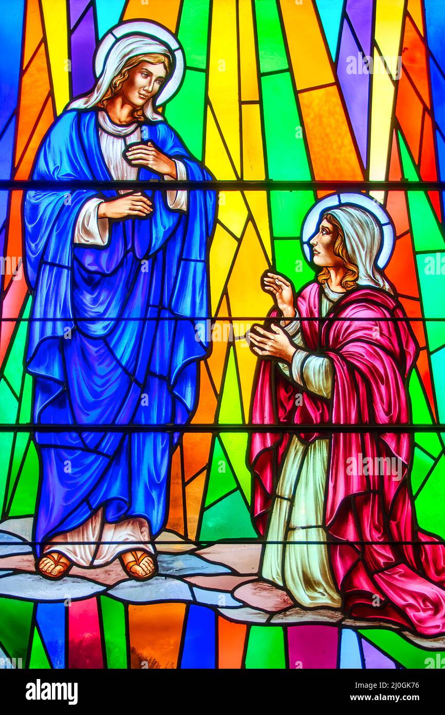 Jesus Christ with Mary Magdalene stained-glass window with Christian religious symbols seen in the Annunciation of the Blessed Virgin Mary Catholic Ch Stock Photo