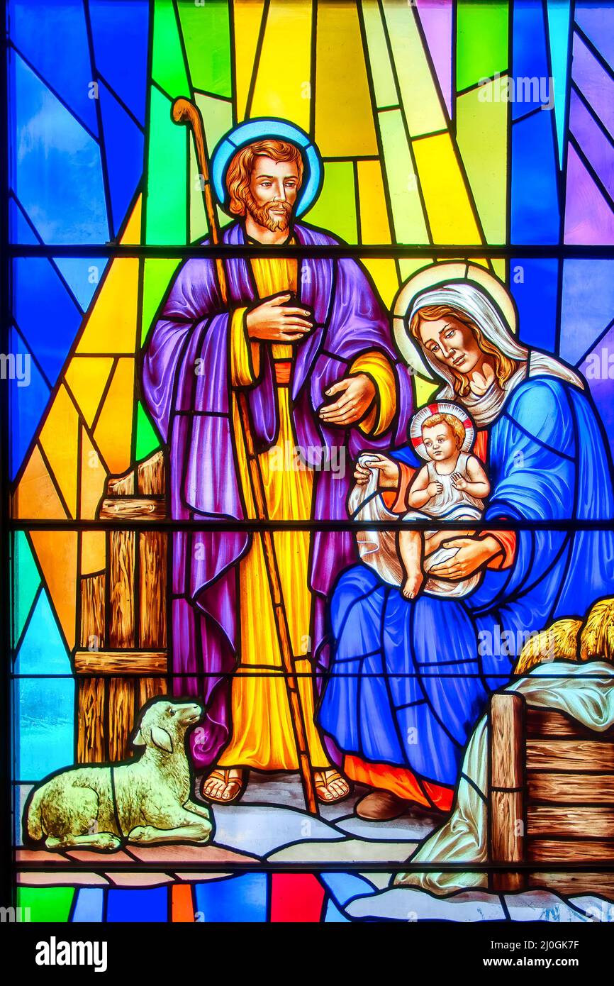 Nativity scene stained-glass window with Christian religious symbols seen in the Annunciation of the Blessed Virgin Mary Catholic Church. Mary, Joseph Stock Photo