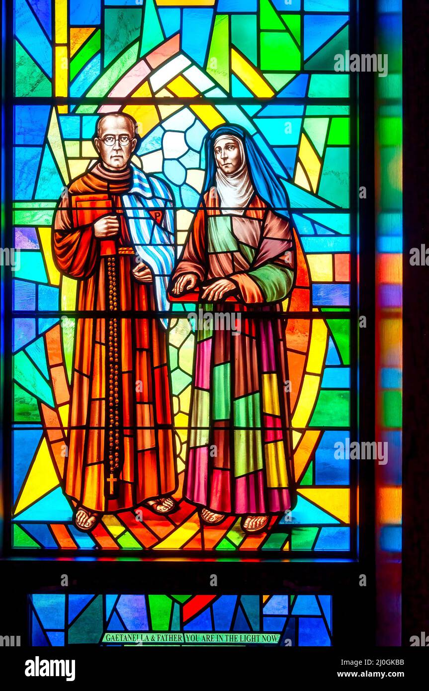 Gaetanella and Father stained-glass window with Christian religious symbols seen in the Annunciation of the Blessed Virgin Mary Catholic Church Stock Photo