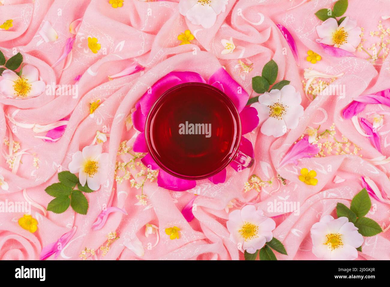 A cup of tea on a background of pink fabric in pink rose flowers Stock Photo