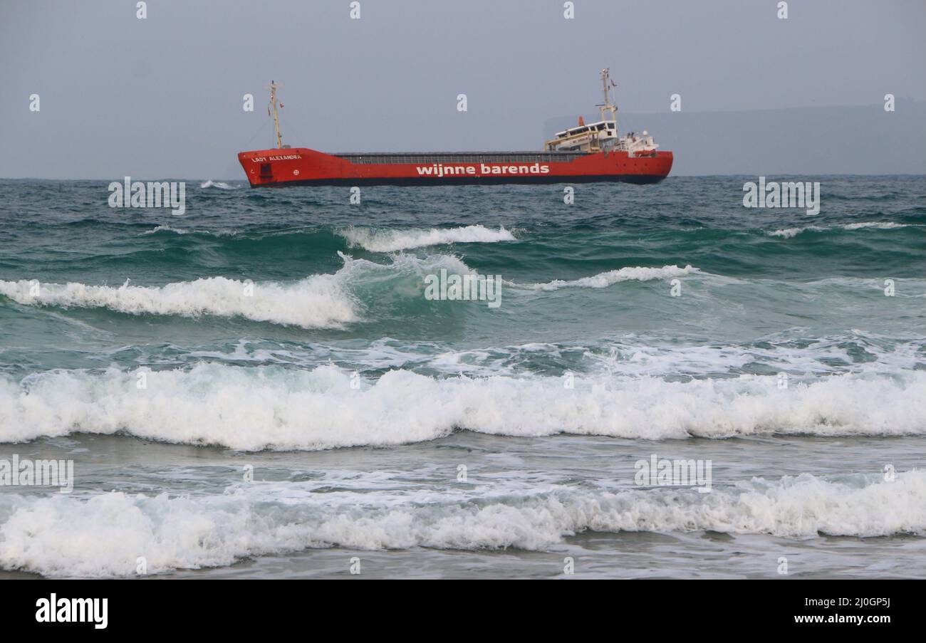 Lady Alexandra cargo ship listing in rough sea while manoeuvring to anchor off the beach Sardinero Santander Cantabria Spain Stock Photo