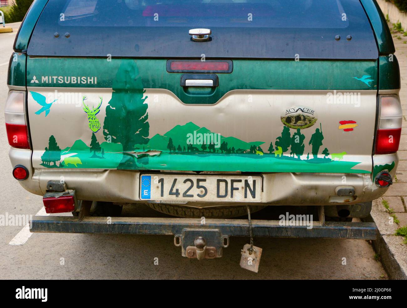 Rear view of a highly decorated parked Mitsubishi L200 pick up truck with green decal landscape hunting scene stickers with Spanish registration Stock Photo