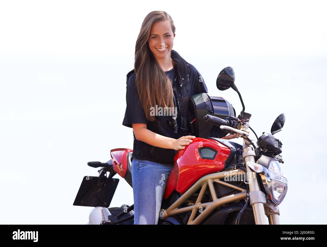 Shes a true biker chick. A beautiful young woman sitting on her red motorcycle. Stock Photo