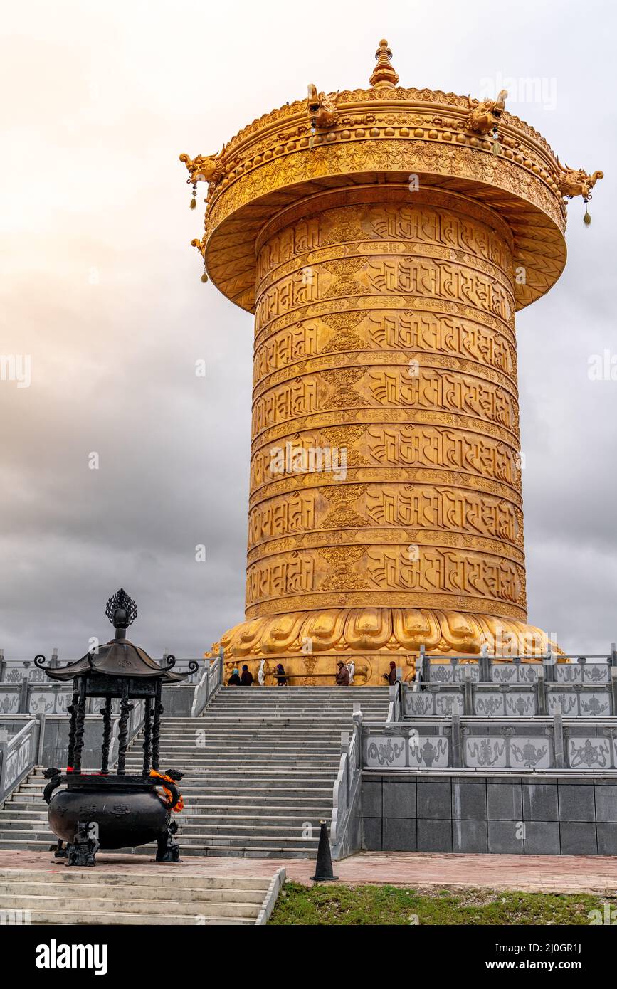 The big golden rolling prayer drum in the tibetan buddhist monastery Stock Photo