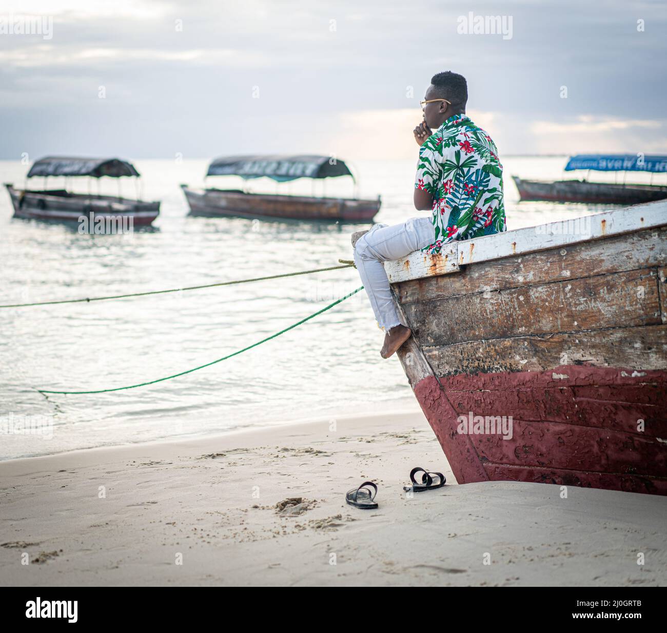 Young black man sitting on boat taking selfie Stock Photo