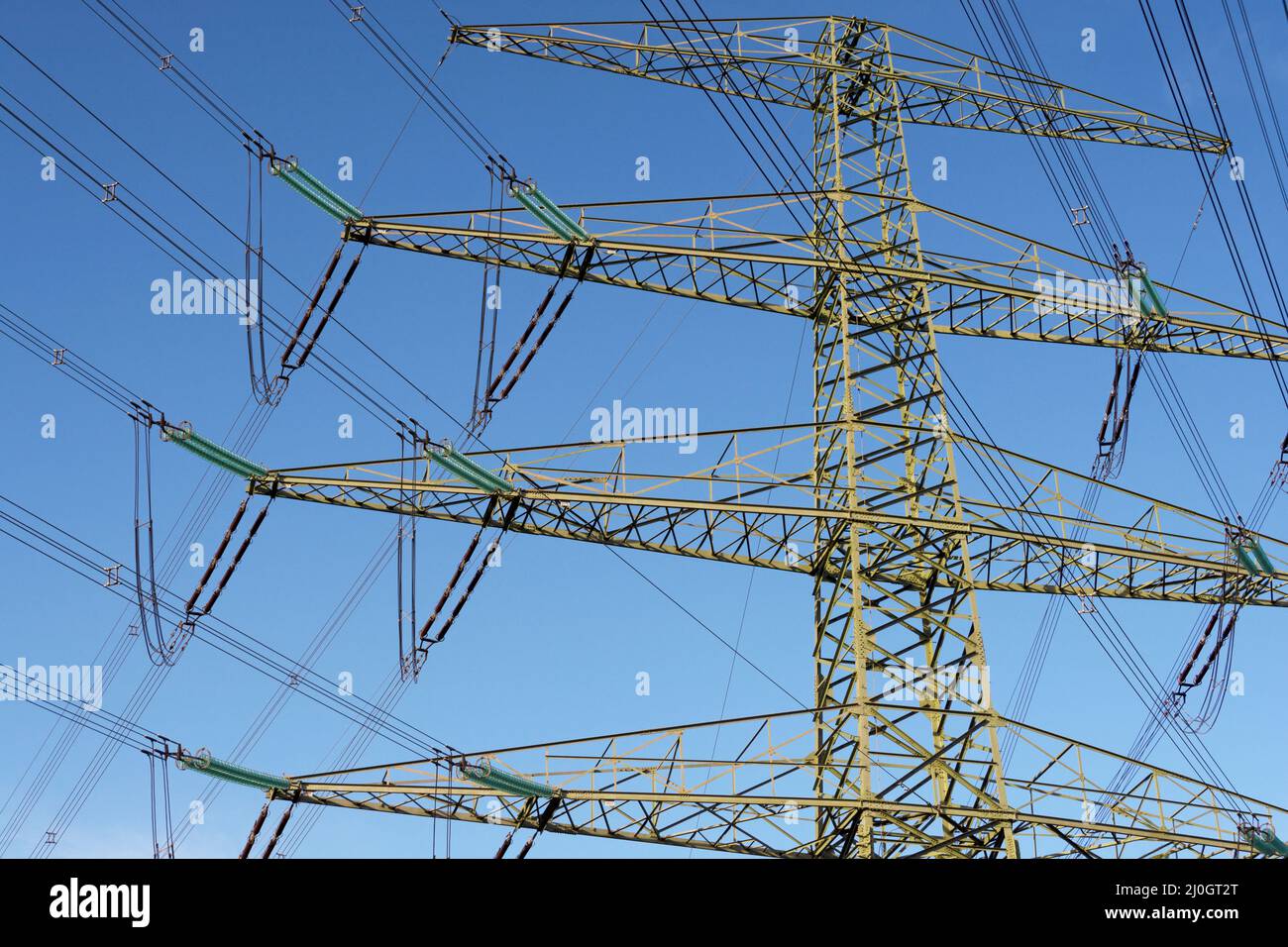 Power grid expansion - modern power pole with blue sky in background Stock Photo