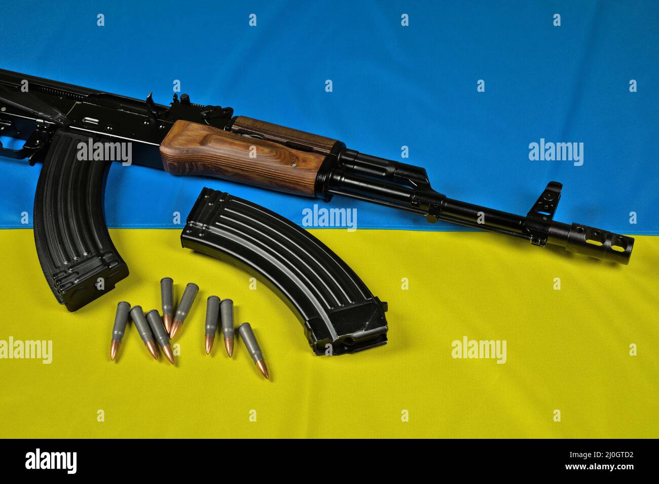 Ak-47 rifle, magazines and ammunition (7,62x39mm) lying on a blue-yellow Ukrainian flag Stock Photo