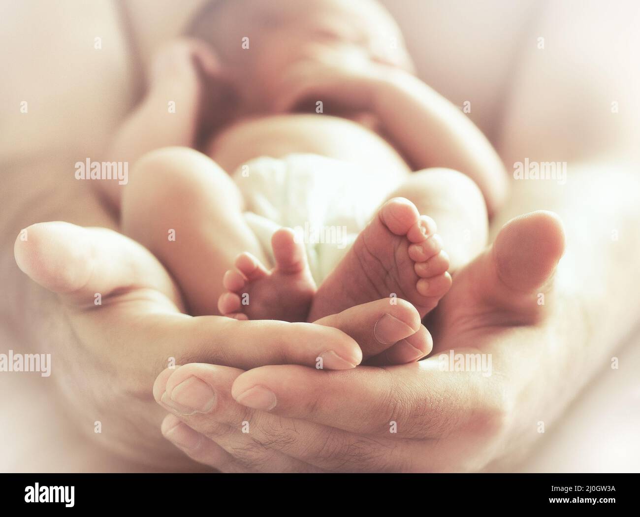 Sleeping newborn baby on male hands Stock Photo