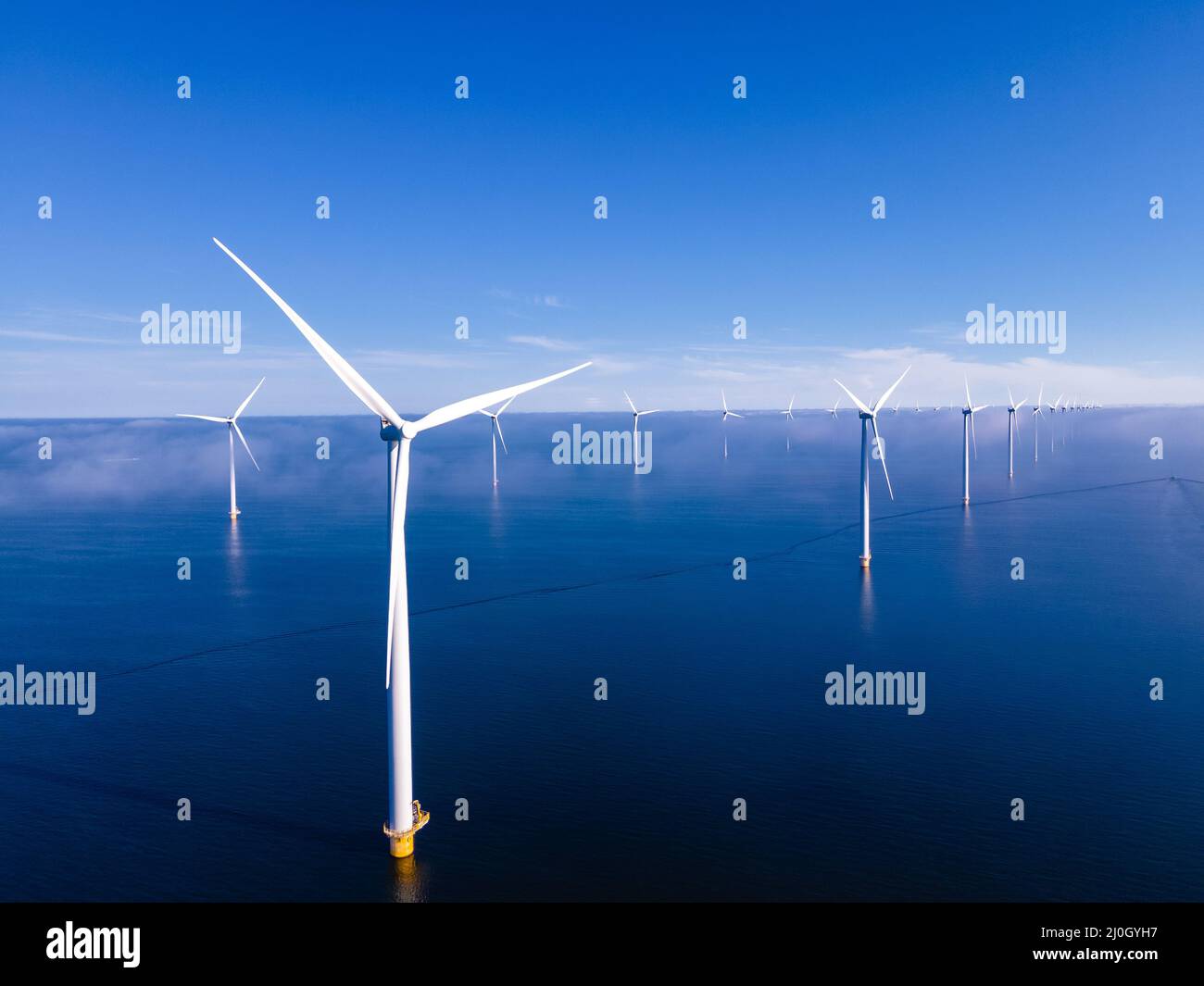 Offshore windmill park with clouds and a blue sky, windmill park in the