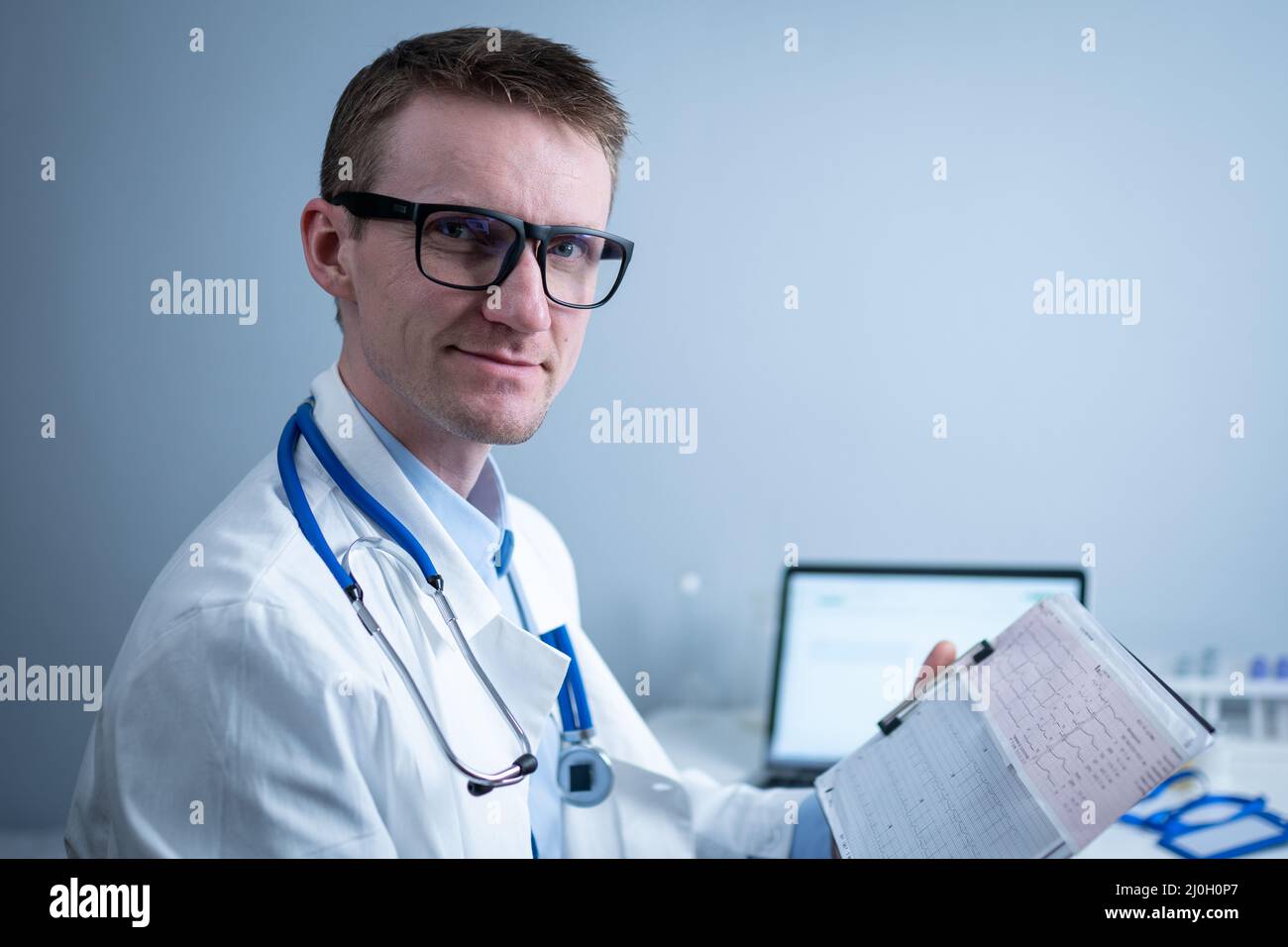 Topic of timely checking for heart disease. Heart disease myocardial infarction. Doctor analyzing electrocardiogram at the desk Stock Photo
