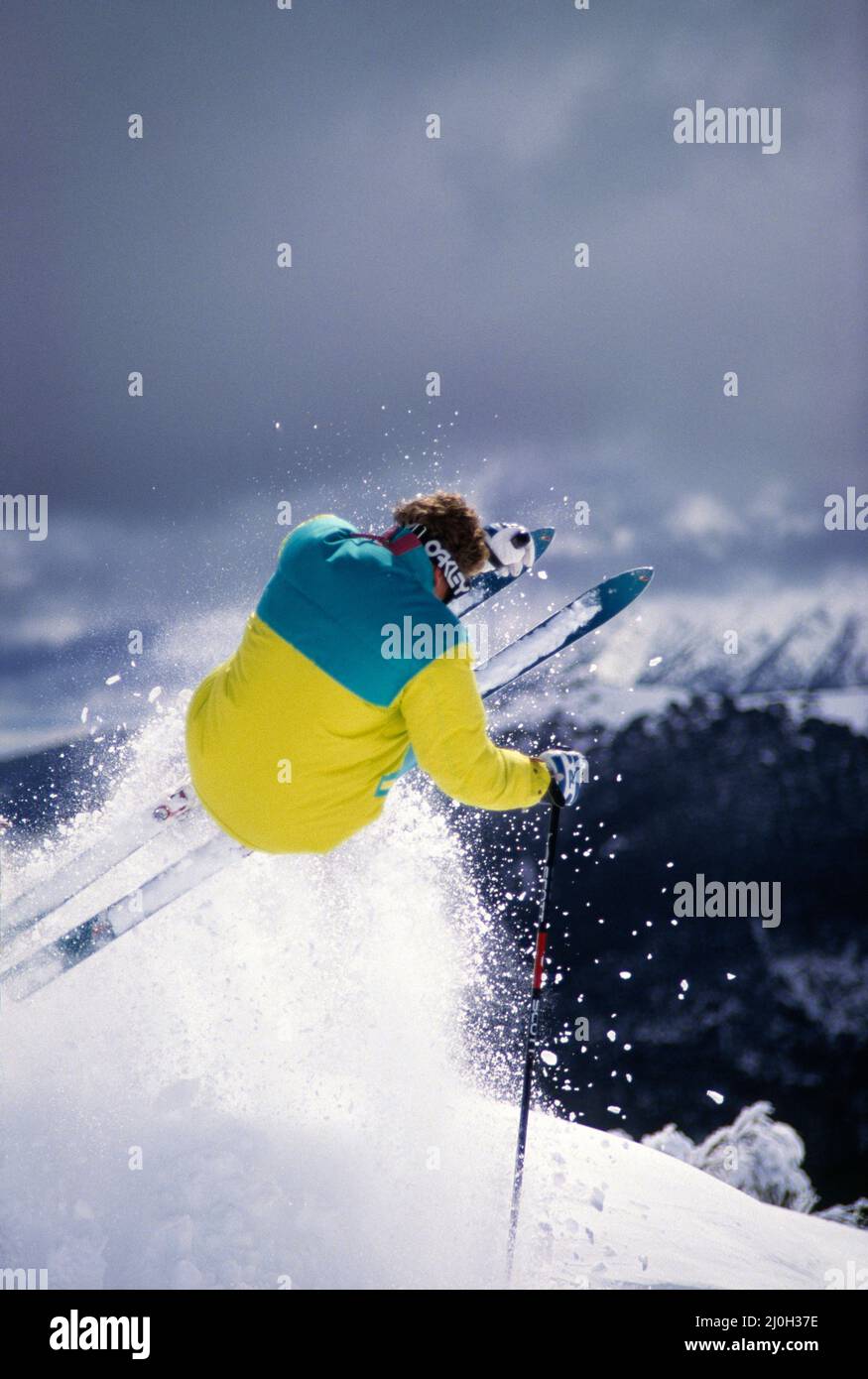 Australia. Snow skiing. Back view of young man downhill skiing jump. Stock Photo