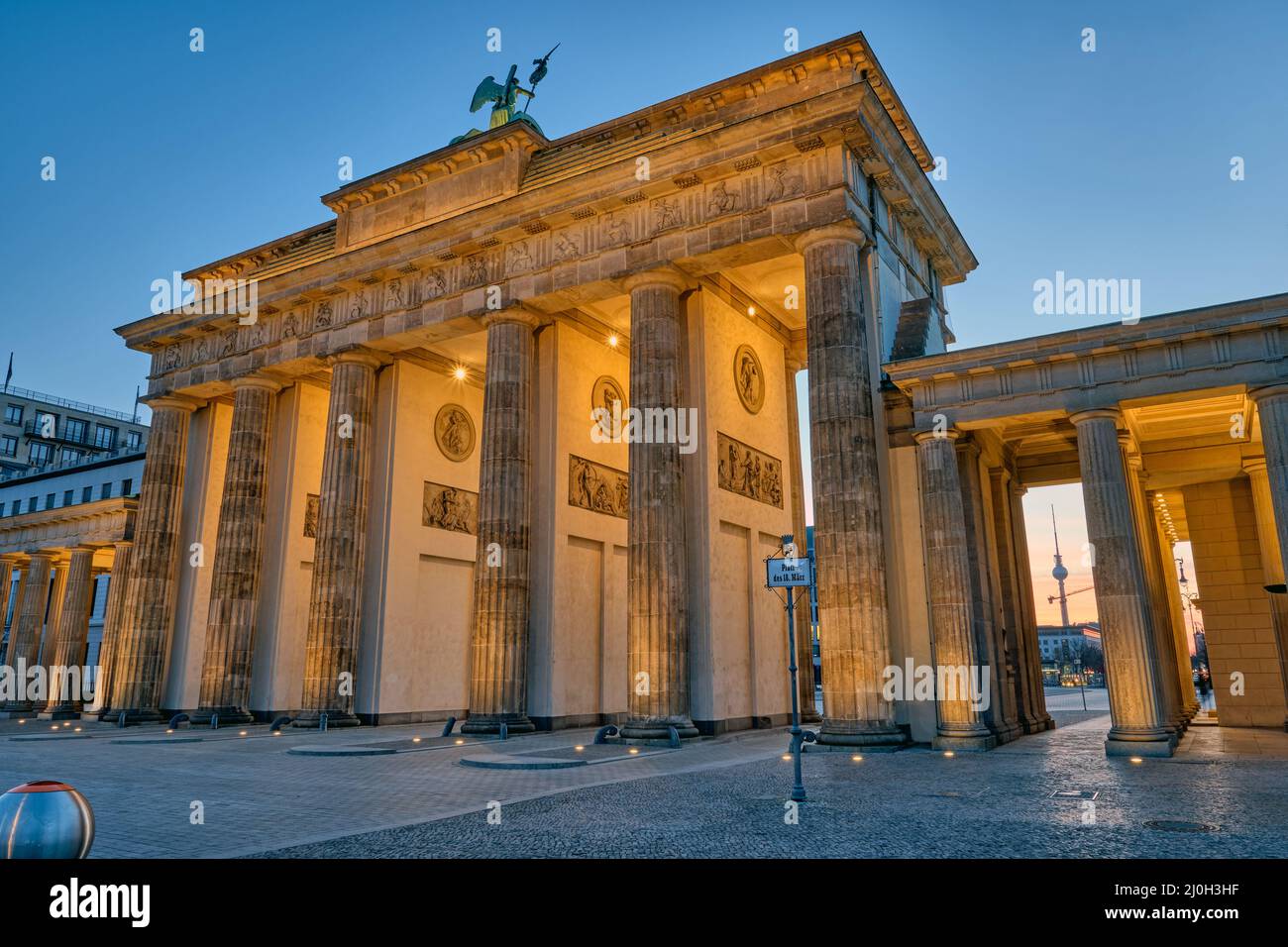 The back side of the famous Brandenburg Gate in Berlin before sunrise with a view to the Television Stock Photo
