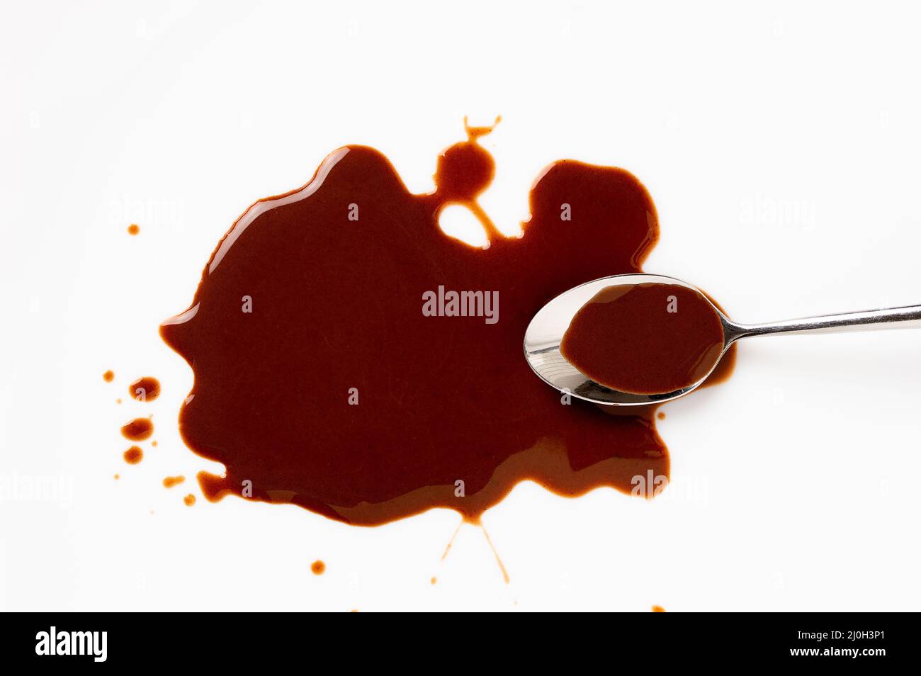 Chocolate sauce and spoon isolated on white Stock Photo