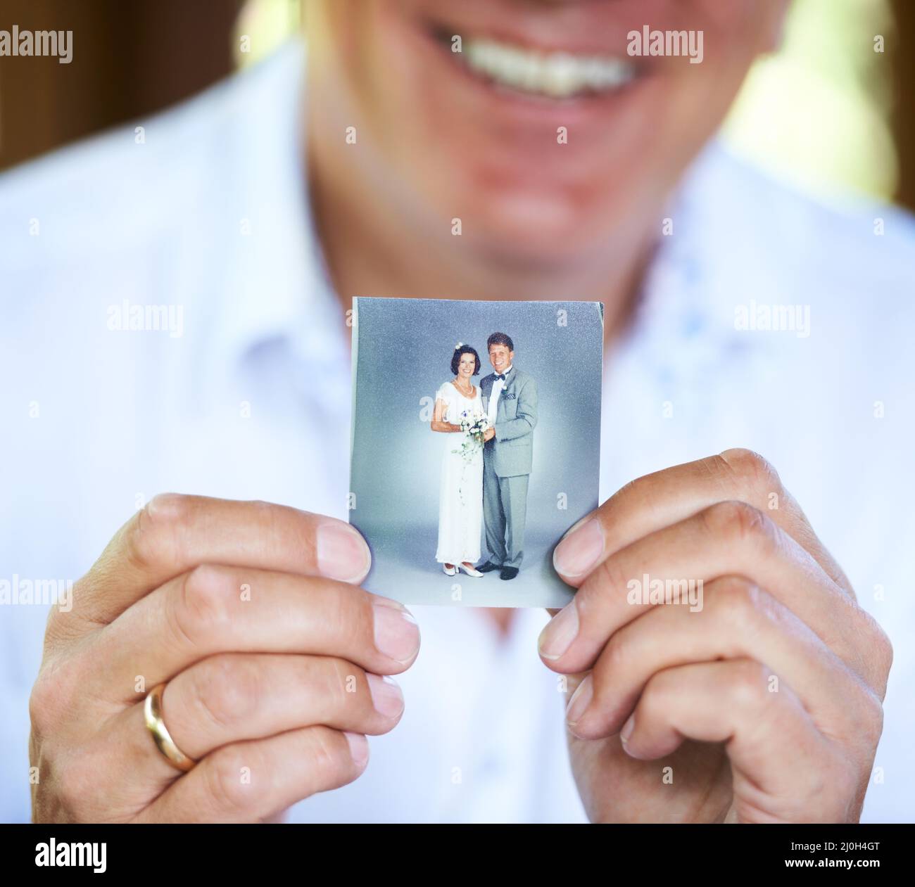 The day we got married.... Cropped image of a person holding up an old wedding photo. Stock Photo