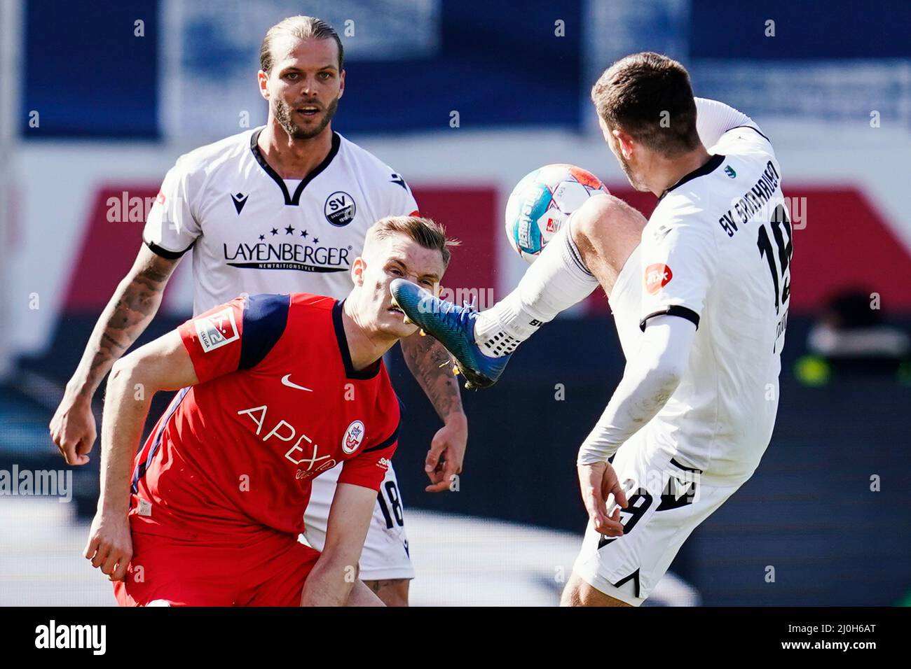 Sandhausen, Germany. 19th Mar, 2022. Soccer: 2. Bundesliga, SV Sandhausen - Hansa Rostock, Matchday 27, BWT-Stadion am Hardtwald. Sandhausen's Dennis Diekmeier (l-r), Rostock's Svante Ingelsson and Sandhausen's Bashkim Ajdini fight for the ball. Credit: Uwe Anspach/dpa - IMPORTANT NOTE: In accordance with the requirements of the DFL Deutsche Fußball Liga and the DFB Deutscher Fußball-Bund, it is prohibited to use or have used photographs taken in the stadium and/or of the match in the form of sequence pictures and/or video-like photo series./dpa/Alamy Live News Stock Photo