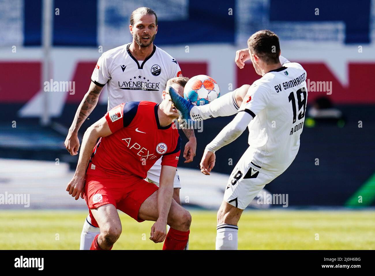 Sandhausen, Germany. 19th Mar, 2022. Soccer: 2. Bundesliga, SV Sandhausen - Hansa Rostock, Matchday 27, BWT-Stadion am Hardtwald. Sandhausen's Dennis Diekmeier (l-r), Rostock's Svante Ingelsson and Sandhausen's Bashkim Ajdini fight for the ball. Credit: Uwe Anspach/dpa - IMPORTANT NOTE: In accordance with the requirements of the DFL Deutsche Fußball Liga and the DFB Deutscher Fußball-Bund, it is prohibited to use or have used photographs taken in the stadium and/or of the match in the form of sequence pictures and/or video-like photo series./dpa/Alamy Live News Stock Photo