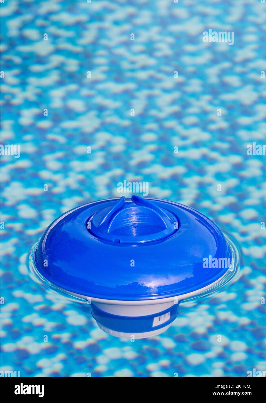 Floating dispenser in the swimming pool, portrait format Stock Photo