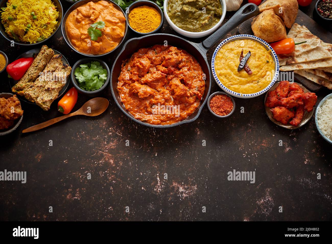 Assortment of various kinds of Indian cousine on dark rusty table Stock Photo