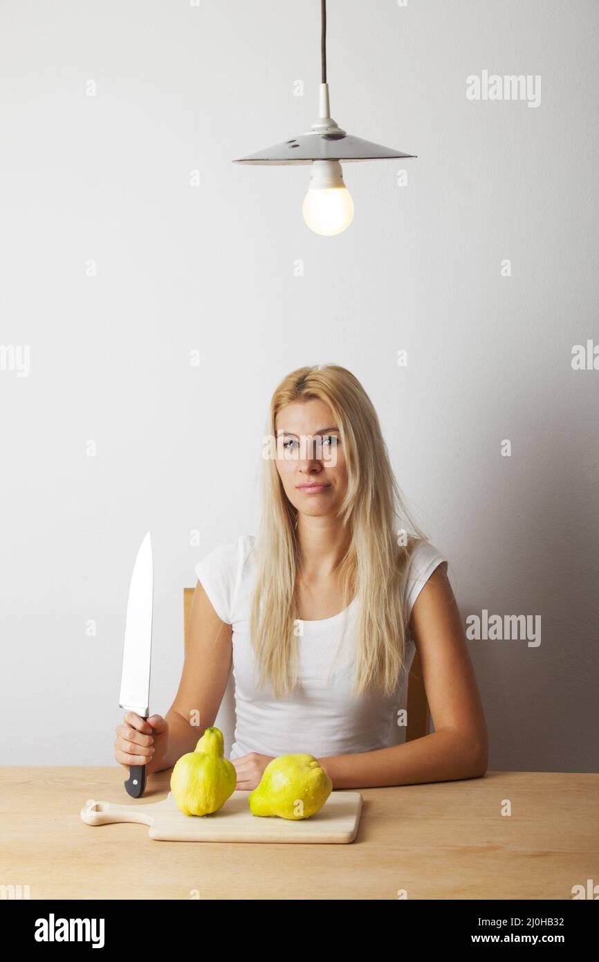 Attractive young blonde woman with a knife Stock Photo