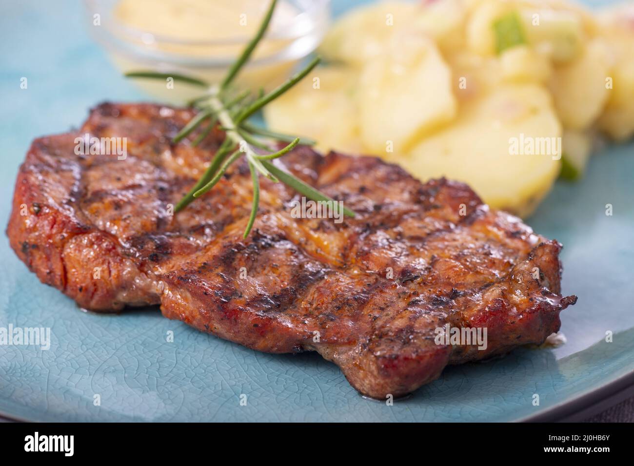 Grilled pork steak with potato salad Stock Photo - Alamy
