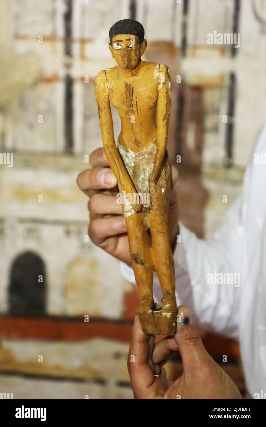 (220319) -- CAIRO, March 19, 2022 (Xinhua) -- An archaeologist shows a statue found in an ancient tomb uncovered at Saqqara archaeological sites southwest of Cairo, Egypt, on March 19, 2022.  The Egyptian Ministry of Tourism and Antiquities announced on Thursday the discovery of five 4,000-year-old ancient tombs in the Saqqara archaeological sites southwest of Cairo.   The tombs contain finds and objects dating back to the end of the Old Kingdom spanning from 2686 BC to 2181 BC and the beginning of the First Intermediate Period spanning from 2181 BC to 2055 BC.   TO GO WITH 'Egypt discovers fi Stock Photo