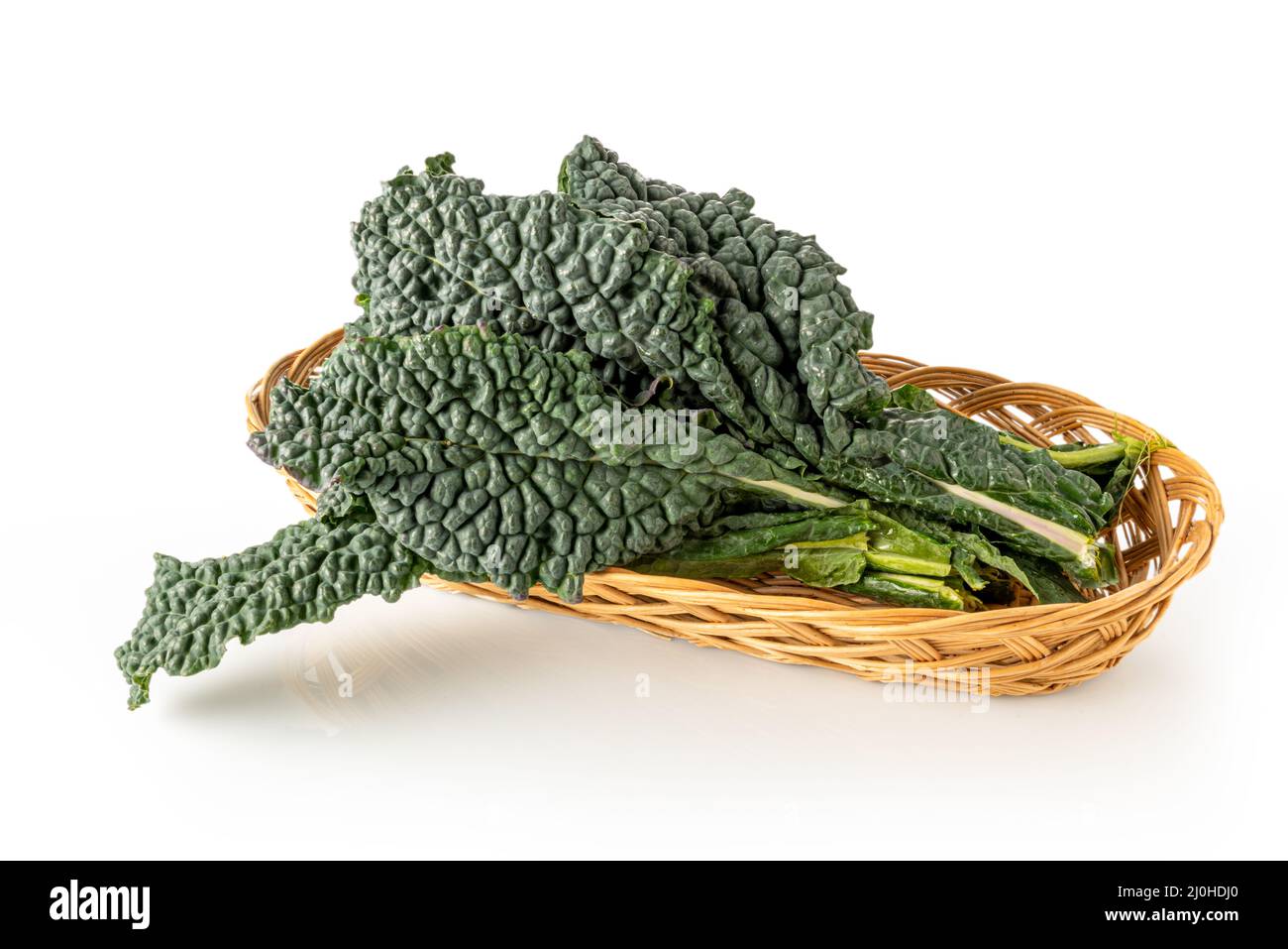 Italian black kale or Tuscan kale or lacinato or dinosaur kale into wicker basket isolated on white Stock Photo
