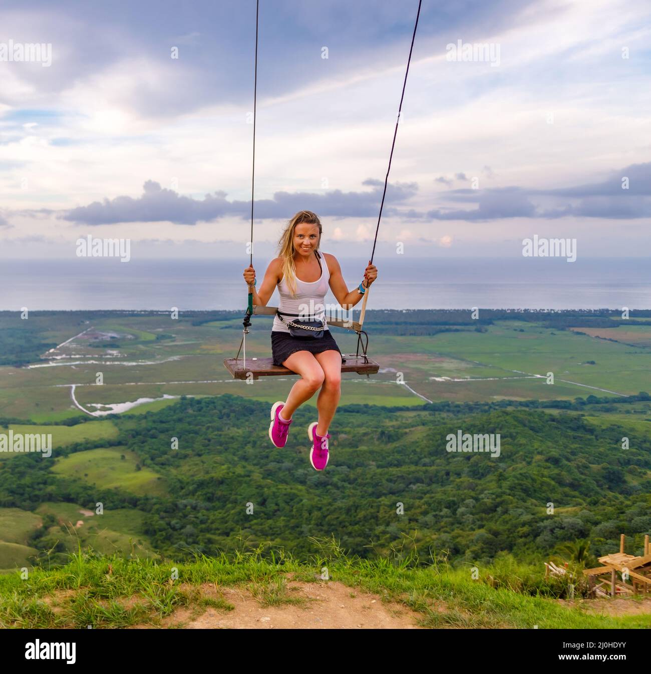 A woman swings on a swing on a high mountain in the Dominican Republic. Tourist place Stock Photo