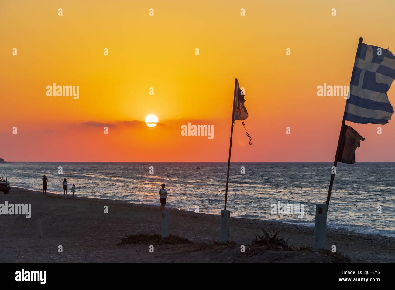 Flags at the most beautiful sunset Ialysos Beach Rhodes Greece. Stock Photo