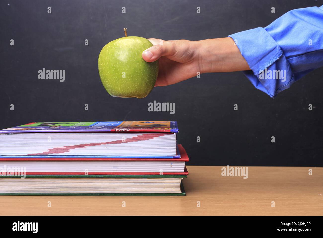 Student puts apple on desk Stock Photo Alamy