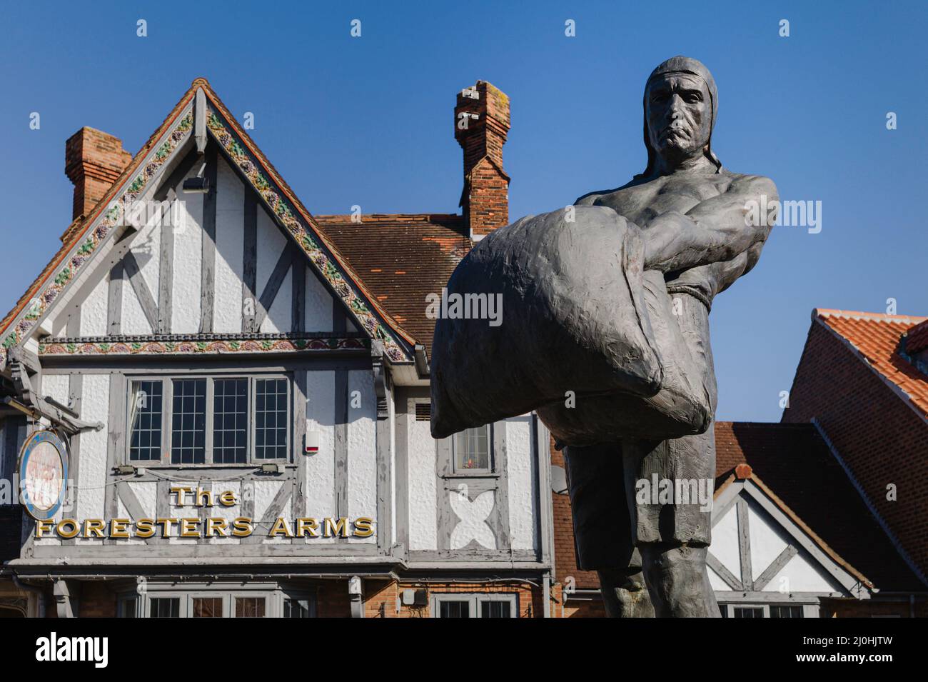 Statue of creeler, a historical labourer employed to move loaded bags from barges, and view of Foresters Arms, public house, Beverley, UK. Stock Photo