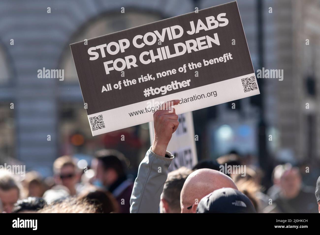 Westminster, London, UK. 19th Mar, 2022.A protest is taking place against vaccinating children for Covid 19, joined by anti-vaxxers. Stop covid jabs for children placard. All of the risk, none of the benefit. #together Stock Photo