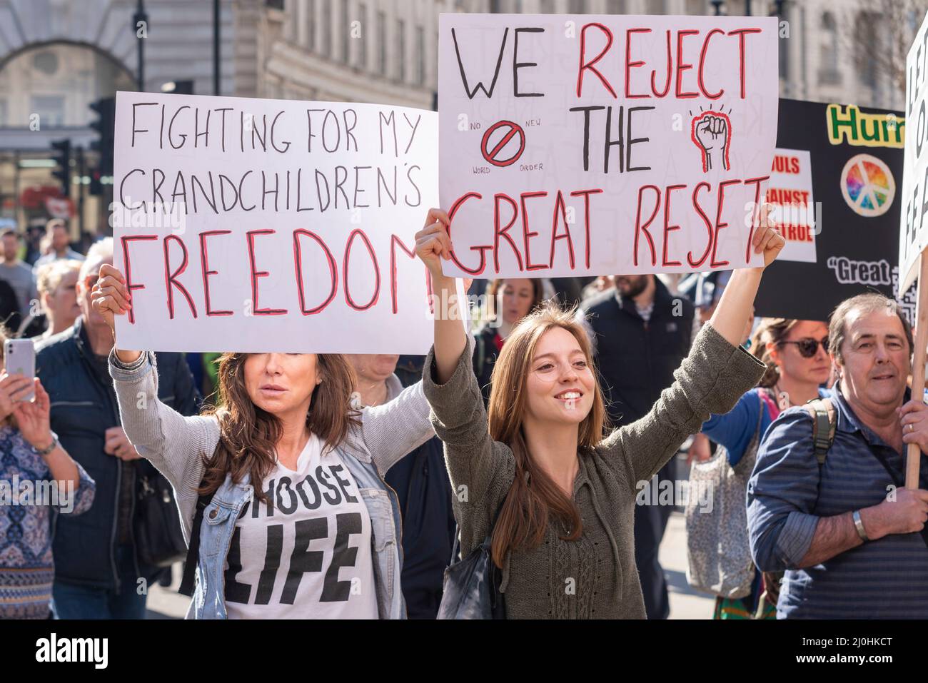 Westminster, London, UK. 19th Mar, 2022.A protest is taking place against vaccinating children for Covid 19, joined by anti-vaxxers. White females holding placards. Fighting for my grandchildren's freedom, and we reject the great reset Stock Photo