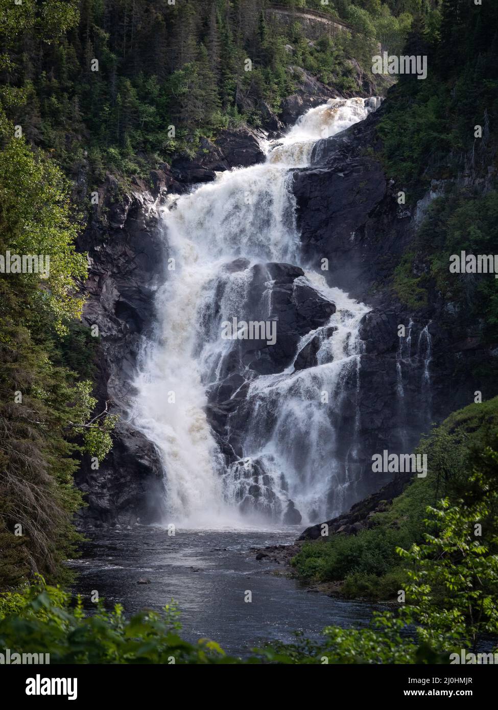 Vertical shot of a waterfall in a forest during the day Stock Photo - Alamy