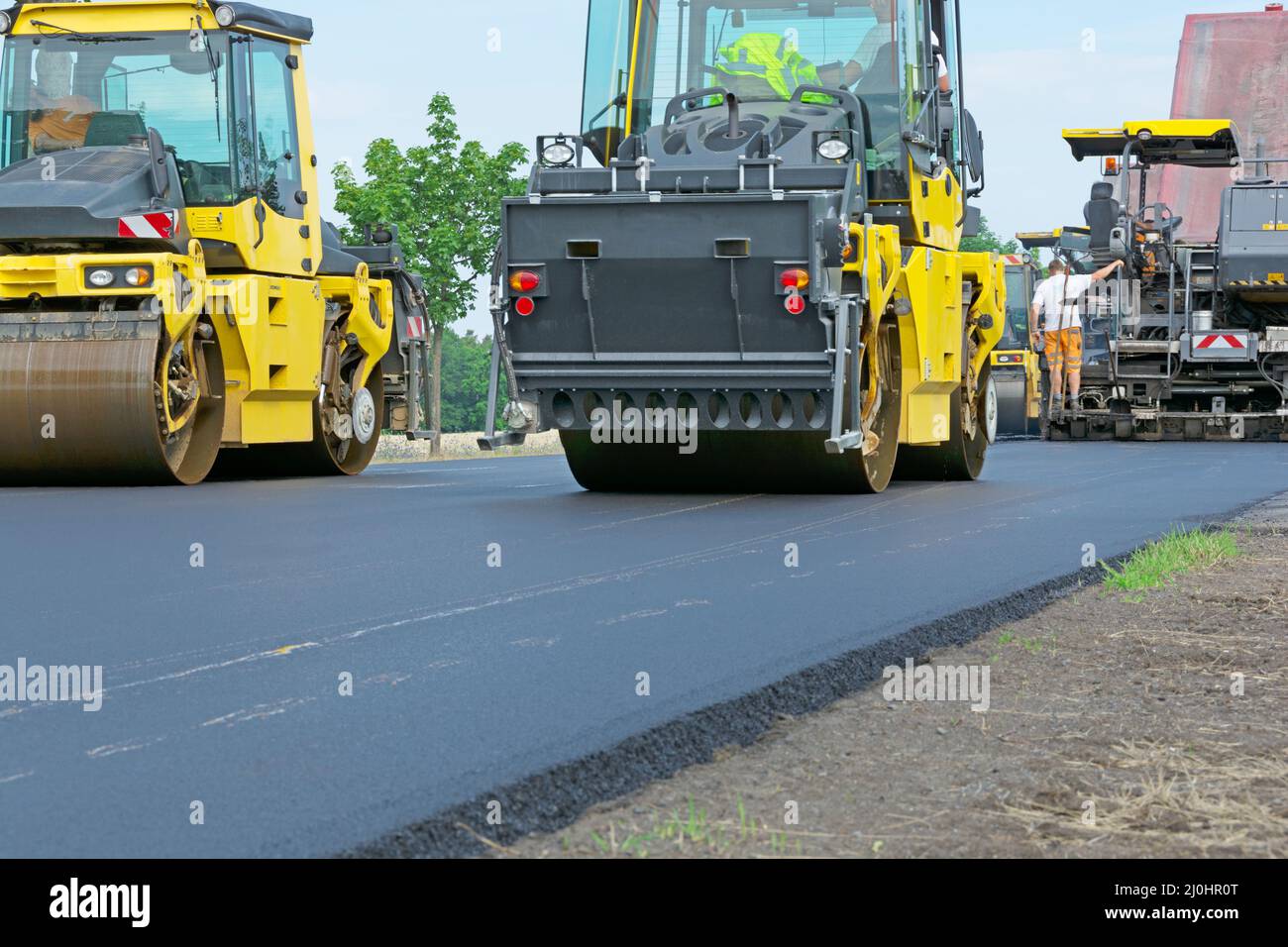 Paving asphalt - road roller and paver in action Stock Photo