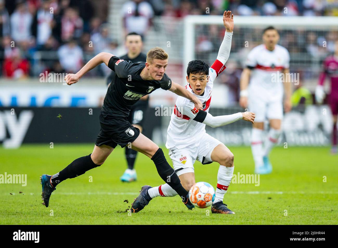 Stuttgart, Germany. 19th Mar, 2022. Soccer: Bundesliga, VfB Stuttgart - FC Augsburg, Matchday 27, Mercedes-Benz Arena. Augsburg's Frederik Winther (l) holds Stuttgart's Wataru Endo (r). Credit: Tom Weller/dpa - IMPORTANT NOTE: In accordance with the requirements of the DFL Deutsche Fußball Liga and the DFB Deutscher Fußball-Bund, it is prohibited to use or have used photographs taken in the stadium and/or of the match in the form of sequence pictures and/or video-like photo series./dpa/Alamy Live News Stock Photo