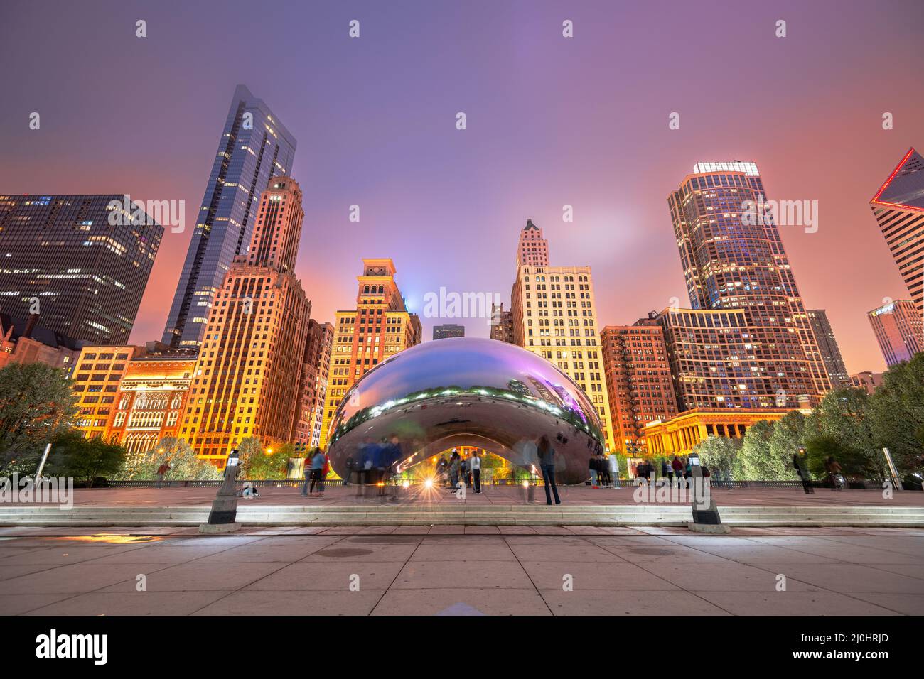 CHICAGO - ILLINOIS: MAY 12, 2018: Tourists visit Cloud Gate in Millennium Park in the evening. Stock Photo