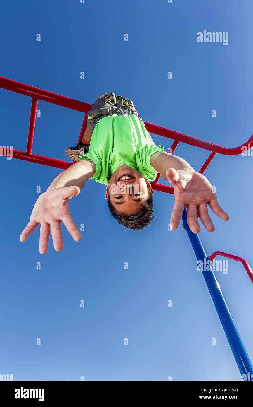 Boy hangs upside down while playing Stock Photo Alamy